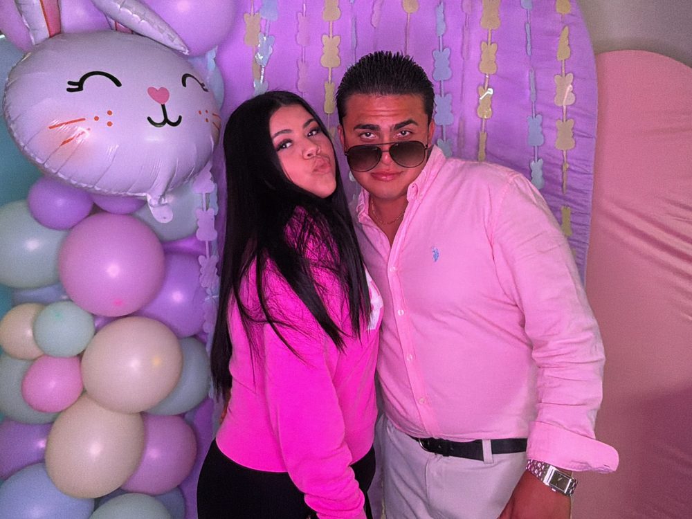 Guests posing at a spring party backdrop